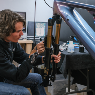 Person applying Ride Wrap frame protection to a suspension fork on a mountain bike.