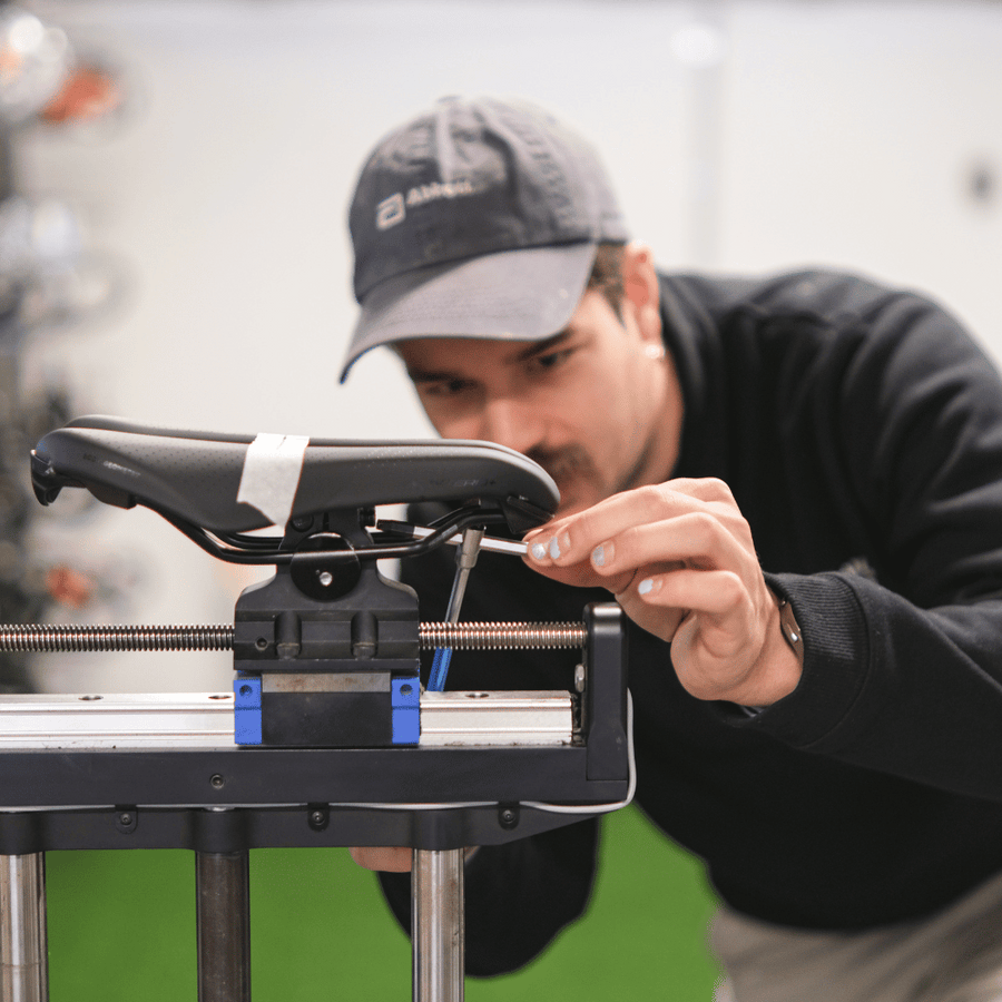 Professional bike fitter adjusting bike saddle on Guru bike fitting machine