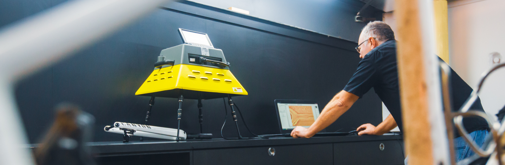 Person working on a computer setup operating a carbon fibre testing machine.